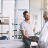 Senior doctor giving his male patient a thorough checkup during his consultation